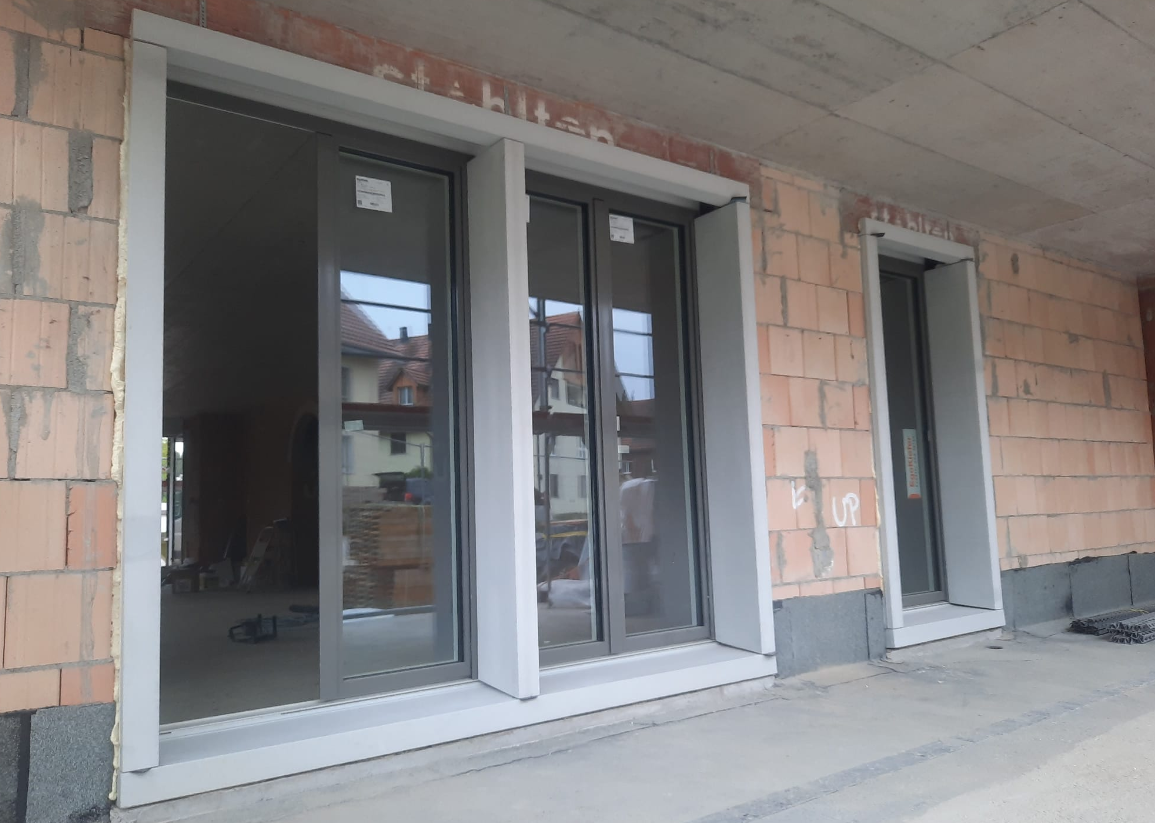 Grosse Fenster- und Türfront in der Fassade eines Neubaus, frisch eingesetzt