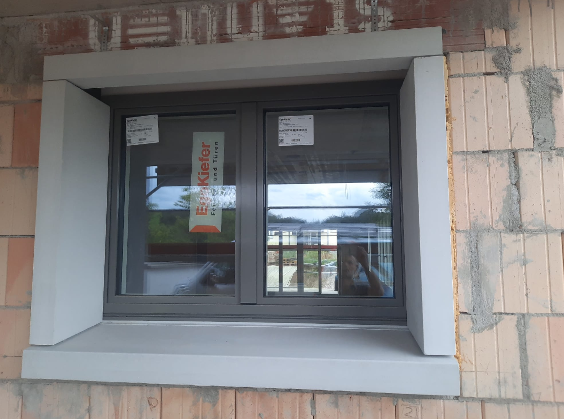 Sauber eingesetztes Fenster mit verputzter Laibung im Backstein-Rohbau